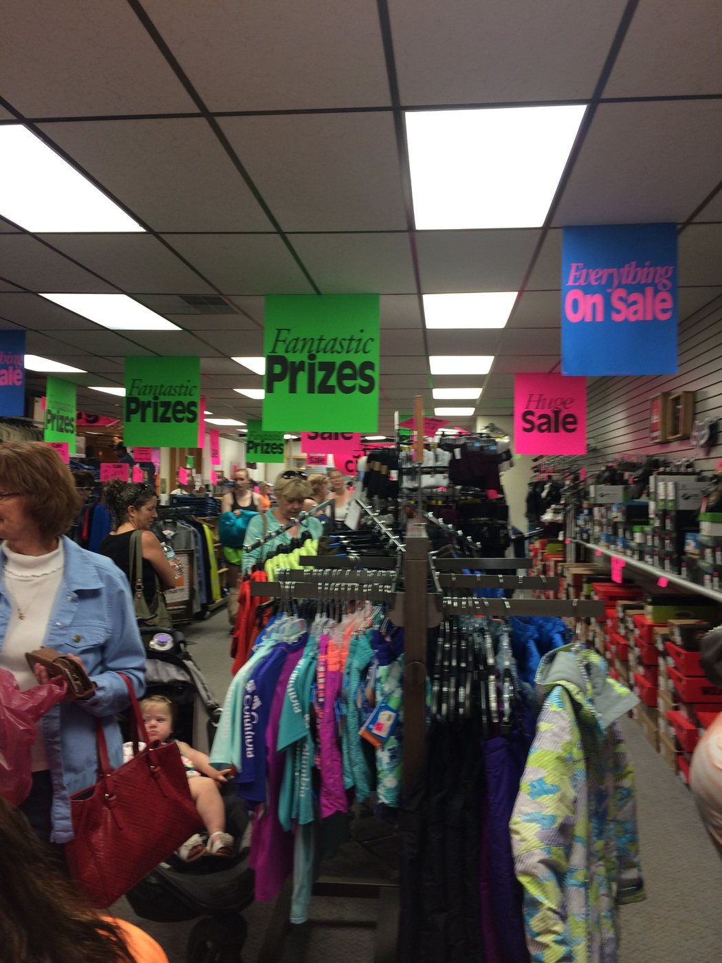 Busy retail sale floor with customers and promotional signs